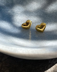 gold heart studs in a bowl