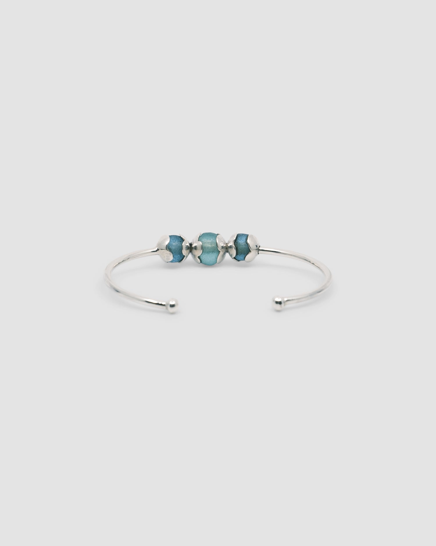 Silver cuff bracelet with 3 central encased sea glass blue beads