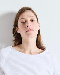Woman wearing a white shirt against a plain background