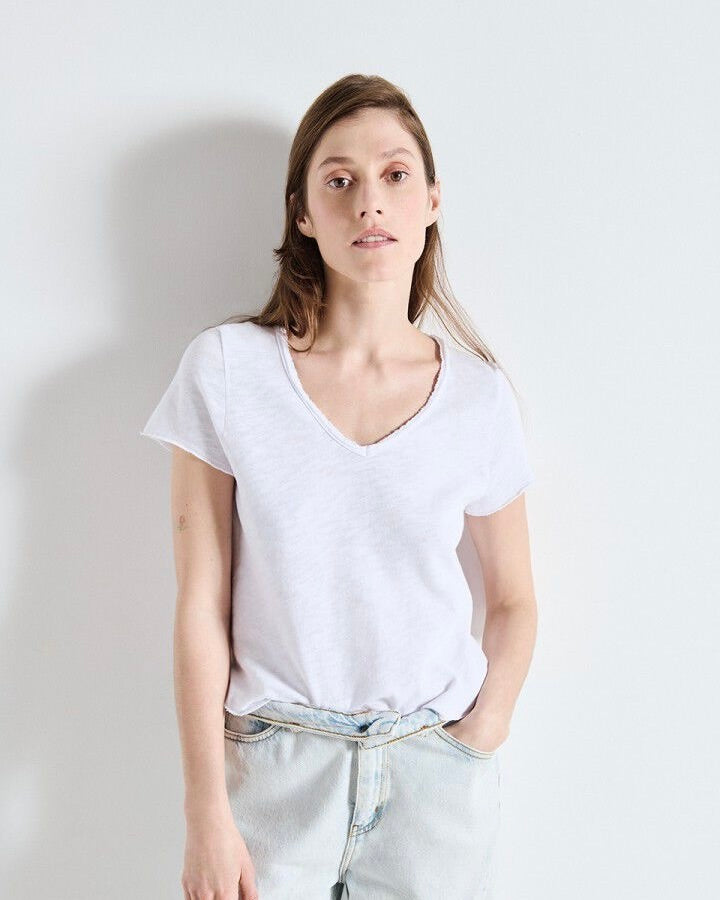 Woman wearing a plain white t-shirt against a light background