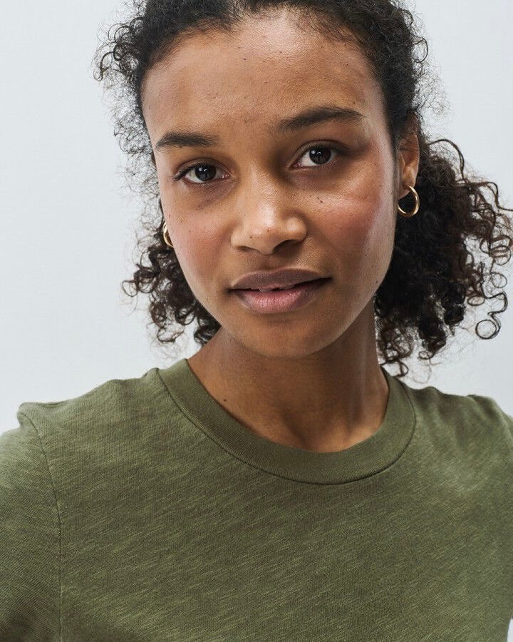 Woman wearing a green t-shirt against a plain background