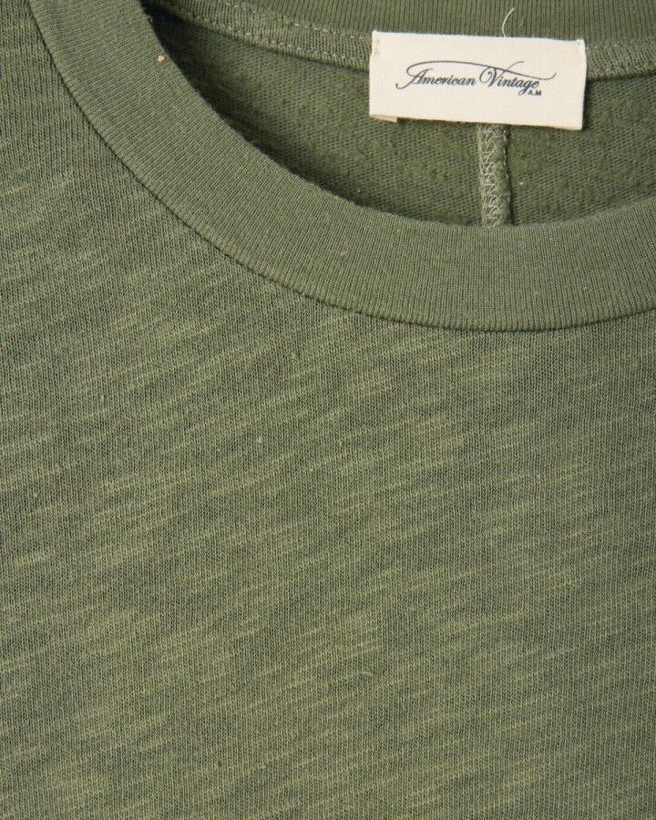 Close-up of a green garment with an 'American Vintage' label.