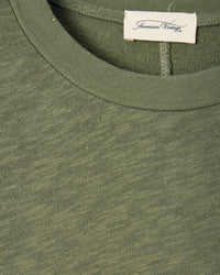 Close-up of a green garment with an 'American Vintage' label.
