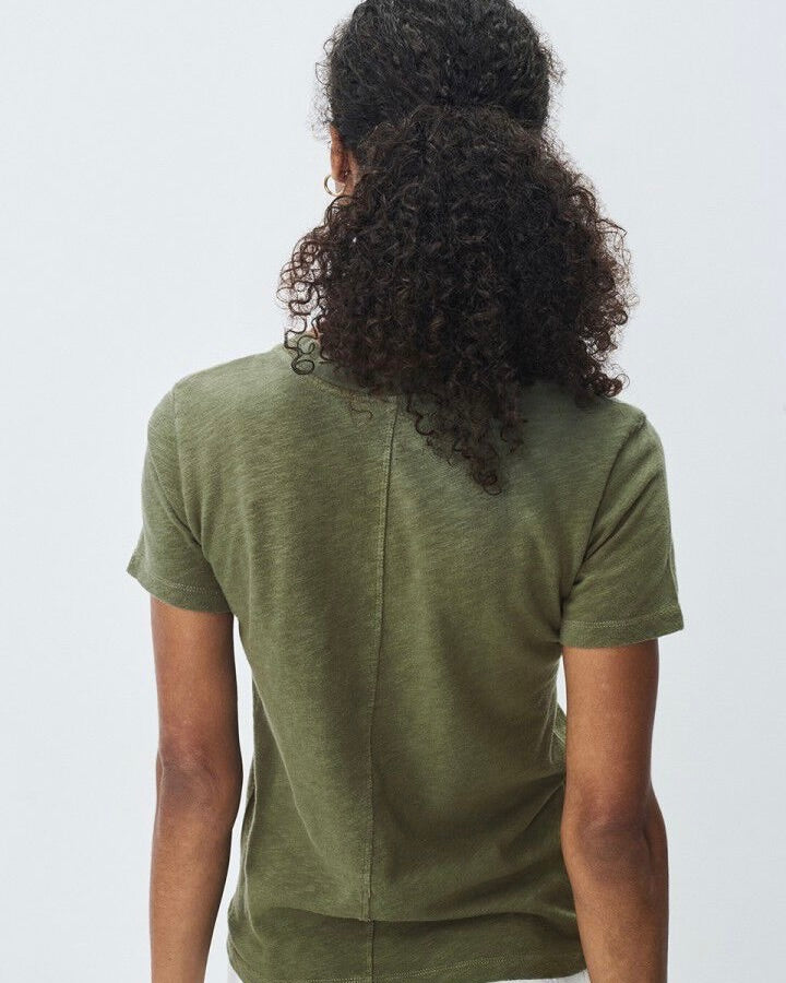 Person wearing a green t-shirt with a plain background