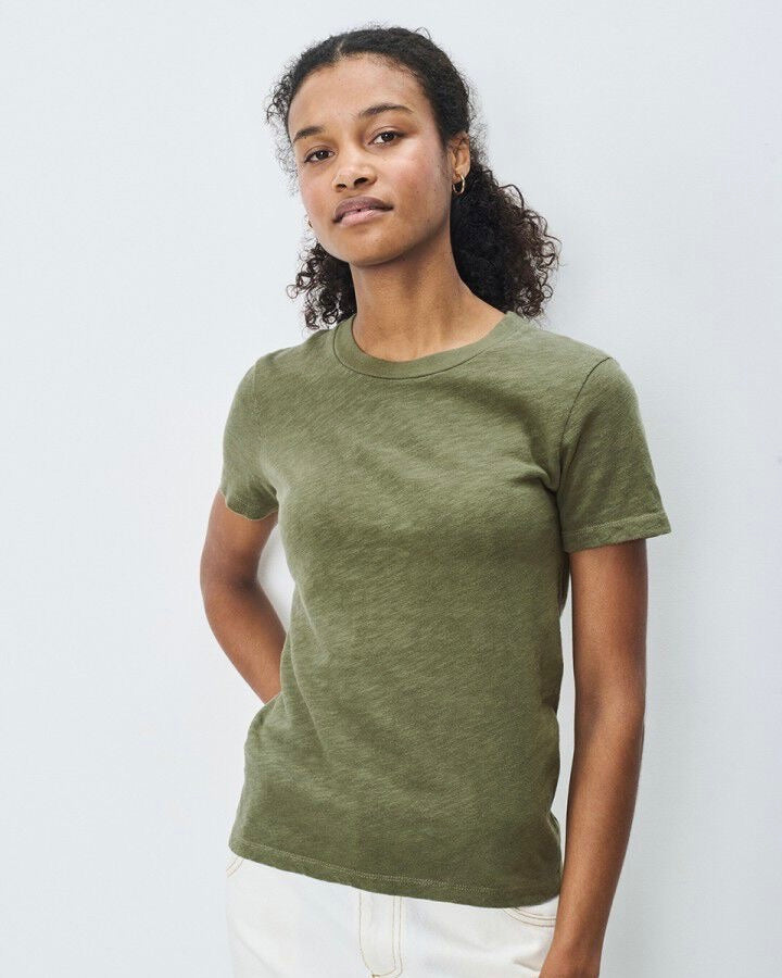 Person wearing a green t-shirt against a plain background