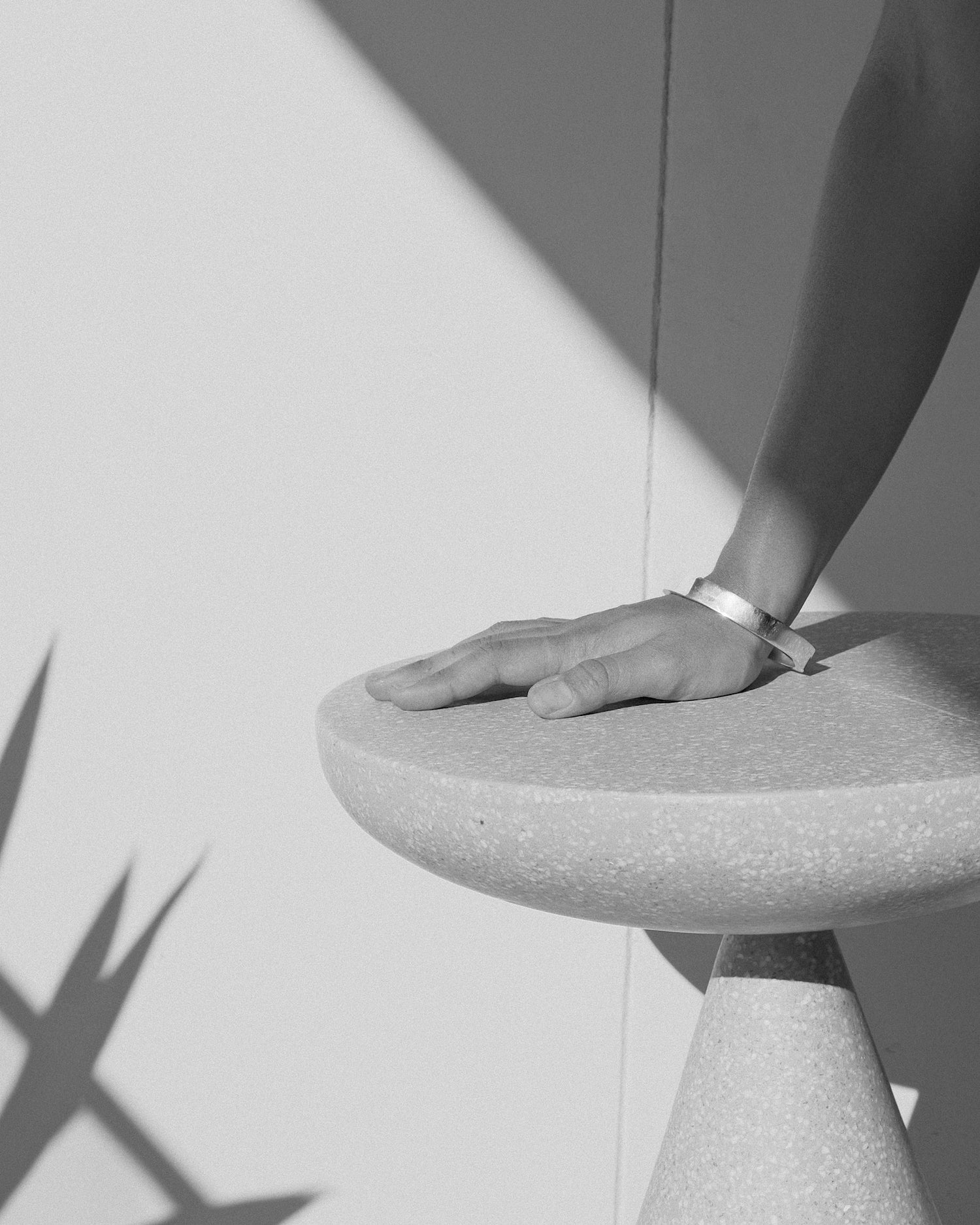 a hand rests on a stool with a bangle on