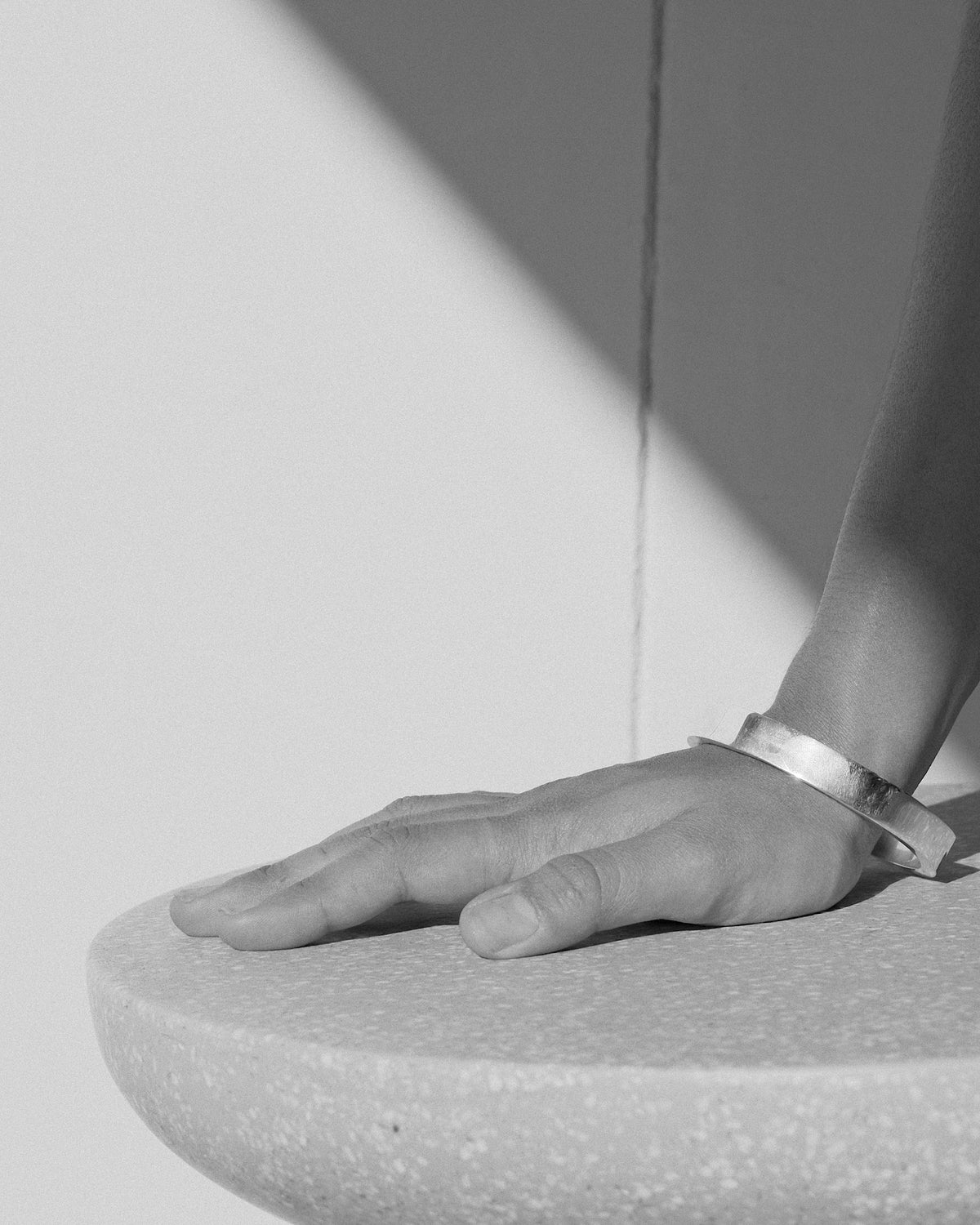 a hand rests on a stool with a bangle