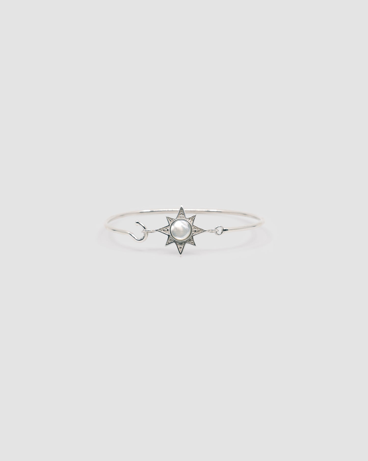 silver with mother or pearl inlaid star features on a thin silver wire clasp bracelet