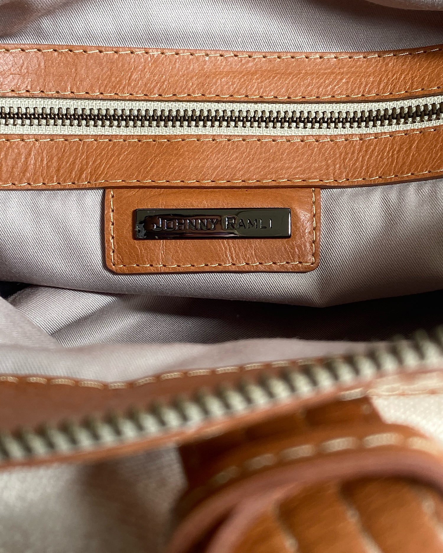 Natural canvas and Tan leather overnight bag with straps on a wall