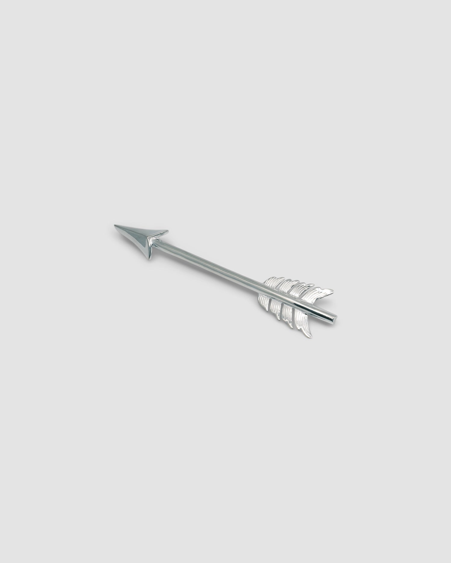 sterling silver arrow brooch on a grey background