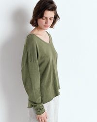 Woman wearing a green oversized shirt against a white background