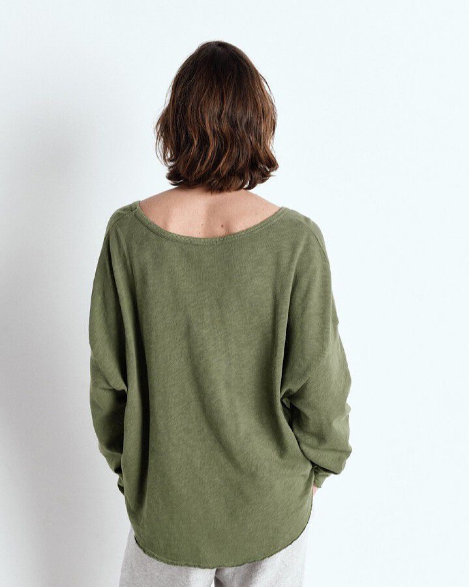 Person wearing a green sweater on a white background