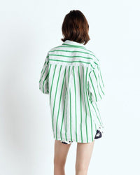 Person wearing a green and white striped shirt on a white background